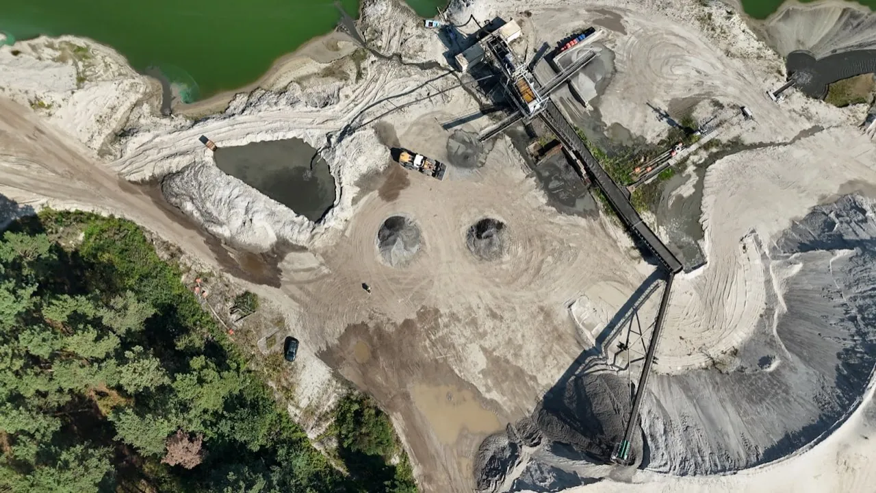 Aerial view of a sand and gravel quarry with bulk material stockpiles and processing plant