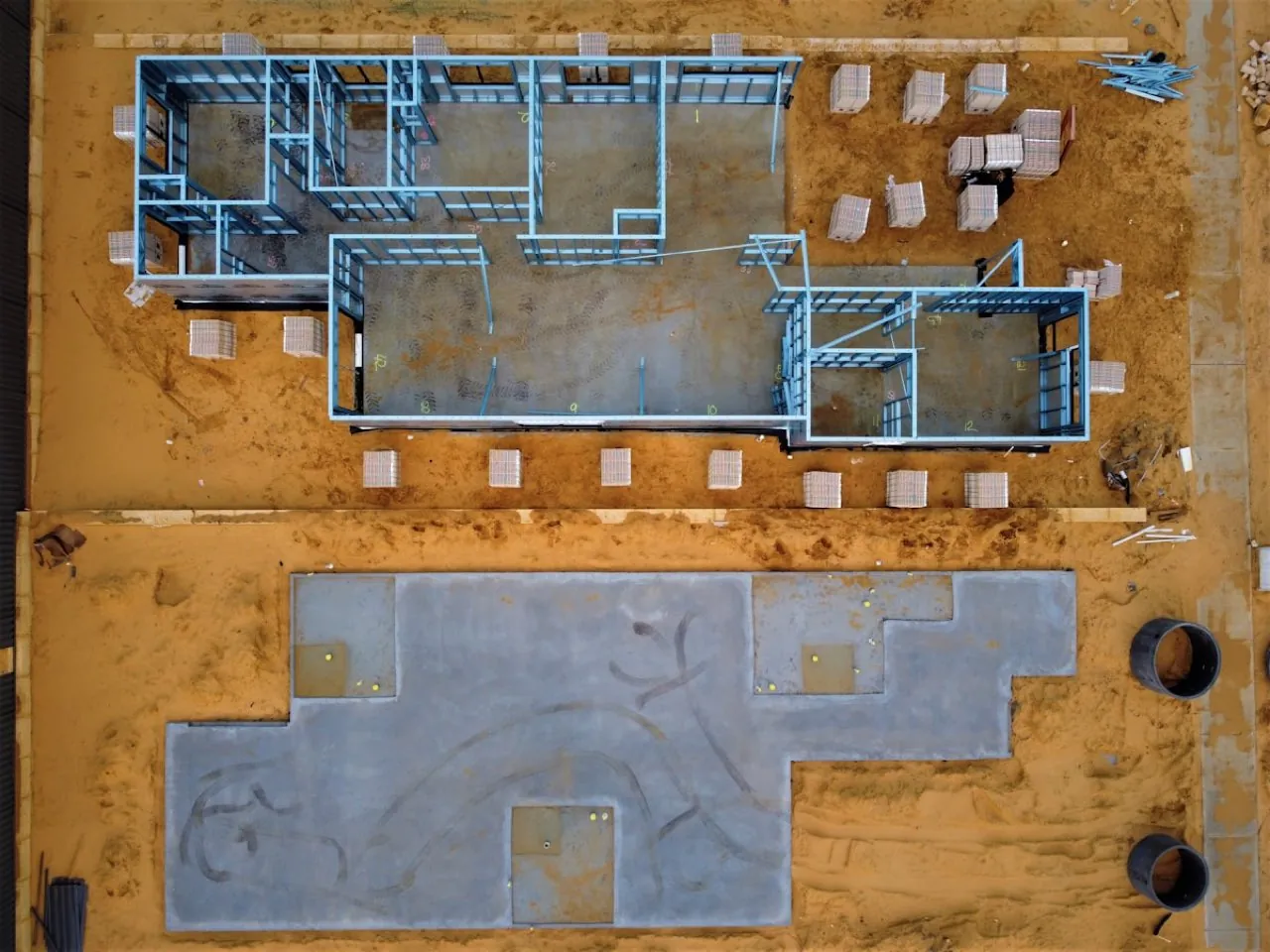 Aerial drone view of a construction site with a building footprint set out and survey grid markers